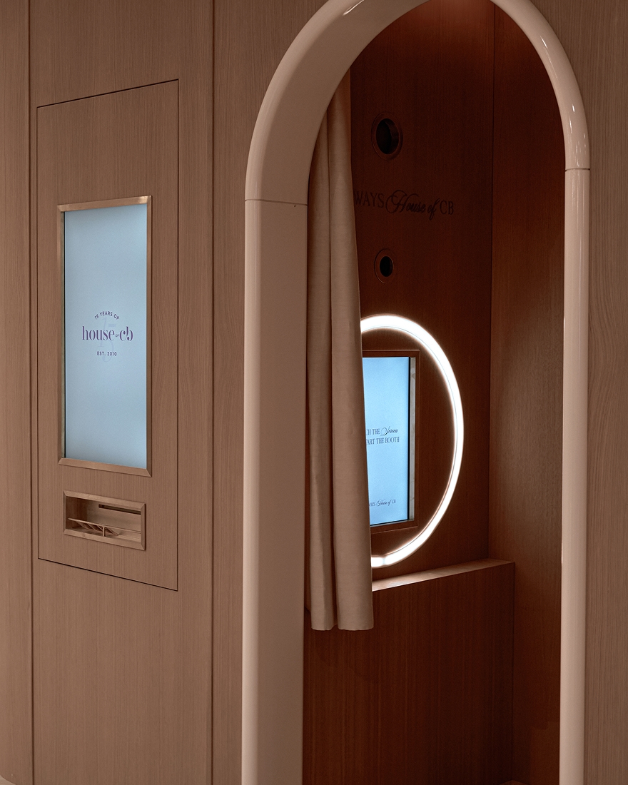 Arched photo booth with illuminated mirror, privacy curtain, and integrated digital display in a contemporary interior